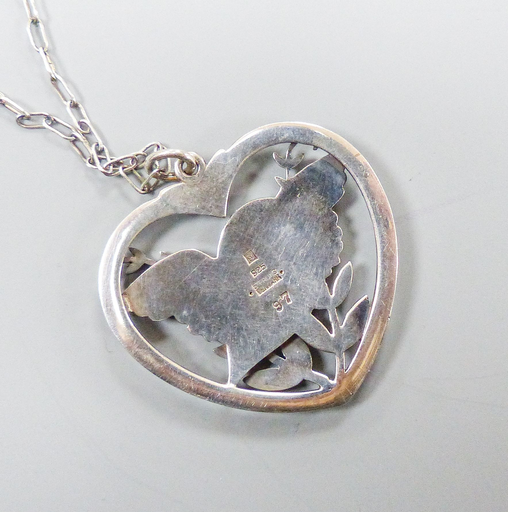 A Georg Jensen sterling 'Robin and frond' heart shaped pendant, no. 97, 38mm, on a white metal chain, 57cm.